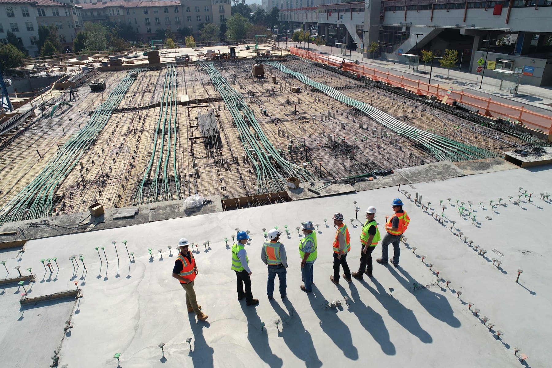A general contractor and crew walking a poured foundation deck